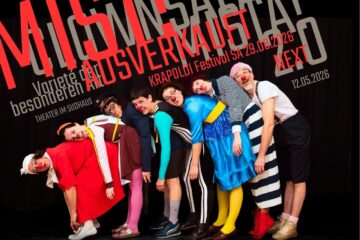 8 Clowns liegen aufeinander und schauen in die Kamera große rote Schrift: MIST AUSVERKAUFT